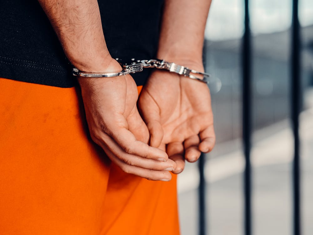 A man wearing orange pants and handcuffs.