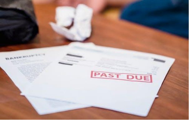 Bankruptcy form and past due bills on a table