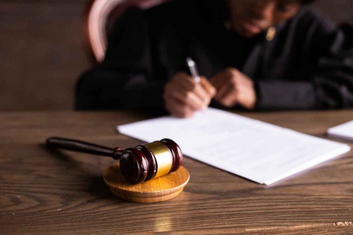 Magistrates' Court judge signing a paper with a gavel beside it